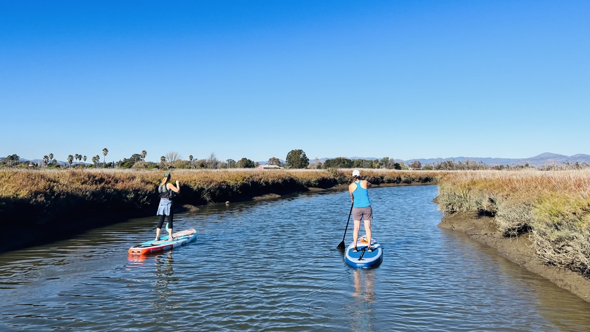 Julie and Karen paddle through a side arm