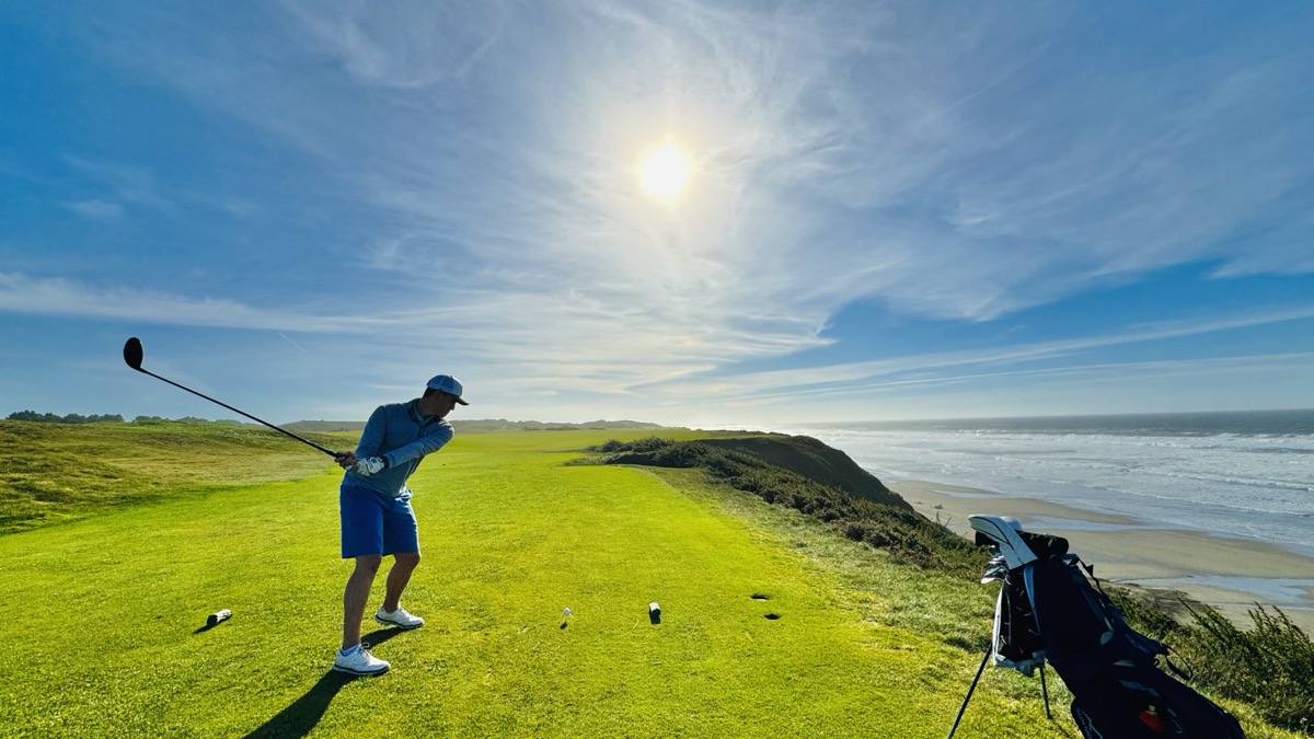 Jacob tees off over the Pacific cliffs